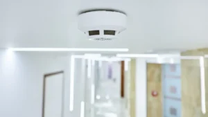 A detailed, close-up view of an automatic fire safety system designed for commercial buildings, highlighting the device's sensors and components on a neutral background.