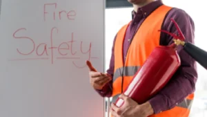 Person holding a red fire extinguisher, demonstrating proper handling and fire safety preparedness in a commercial setting