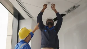 Professional fire sprinkler technician installing sprinkler pipes in a commercial building