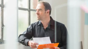A school administrator conducts a fire safety review with a checklist in hand, ensuring the building meets inspection requirements for student and staff safety.